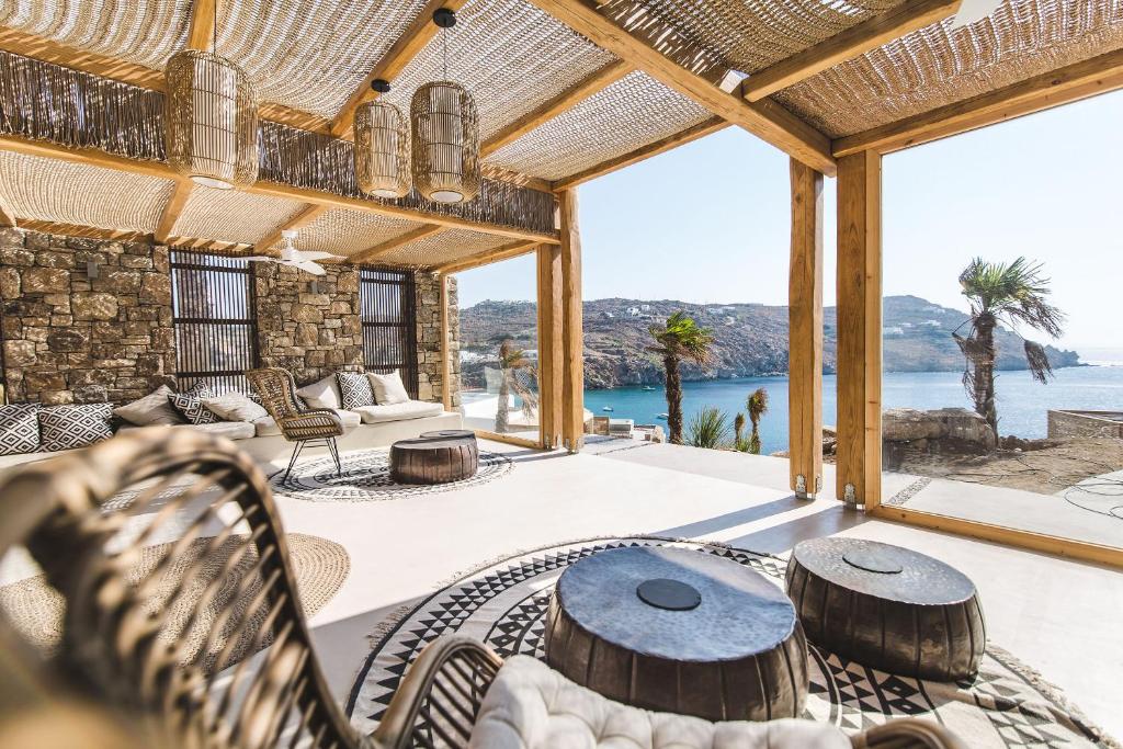 a patio with a table and chairs and a view of the ocean at Nimbus My Aktis in Super Paradise Beach