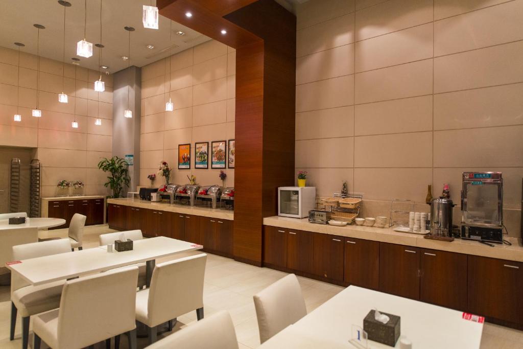 a restaurant with white tables and chairs and a counter at Jinjiang Inn Select Zhongwei Shapotou Shui Town in Zhongwei