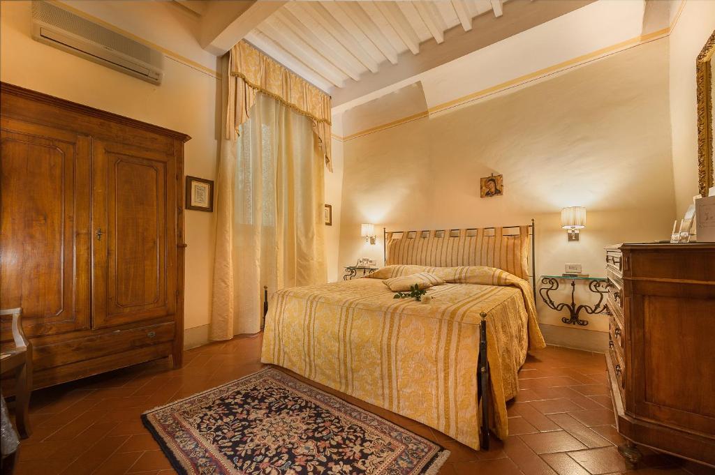 a bedroom with a bed and a dresser at B&B Piccolo Hotel in Cortona