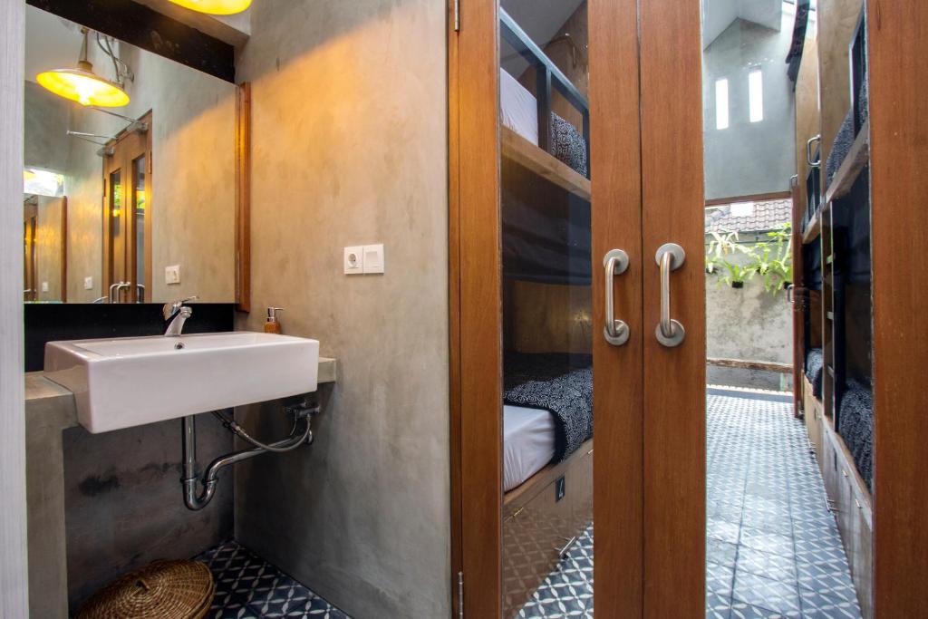 een badkamer met een wastafel en een spiegel bij Sunshine Vintage House in Ubud