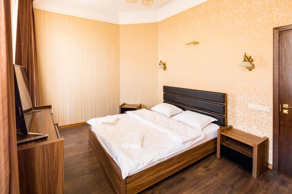 リヴィウにあるLEOGRAND Apartments on Doroshenka Street 1のベッドルーム(白いシーツを使用した大型ベッド1台付)