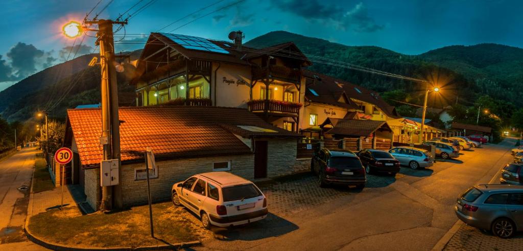 um grupo de carros estacionados em frente a um edifício em Penzión Gitka em Vrútky