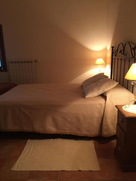 a bedroom with a large bed with two lamps on it at Los Abetos in Abay