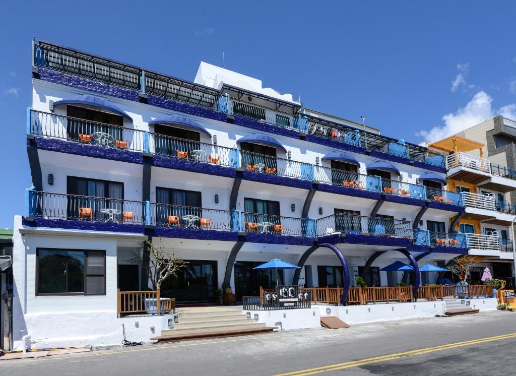 un edificio bianco con balconi blu su una strada di Kenting Coast Resort a Kenting