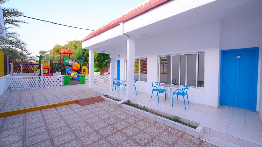 a house with a patio with chairs and a playground at Fujairah Hotel & Resort in Fujairah