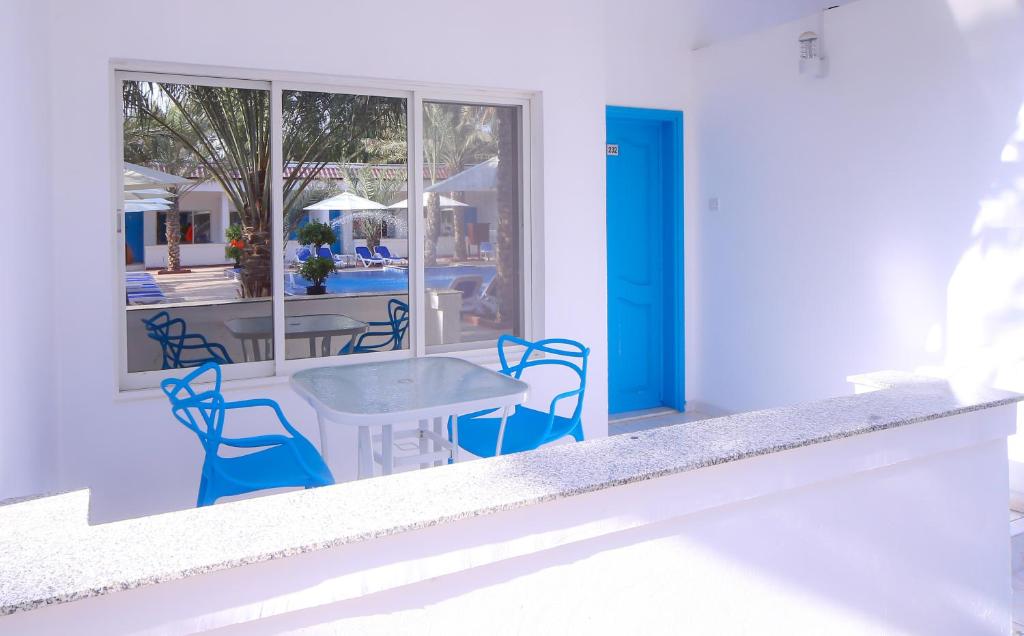 a patio with a table and chairs and a pool at Fujairah Hotel & Resort in Fujairah