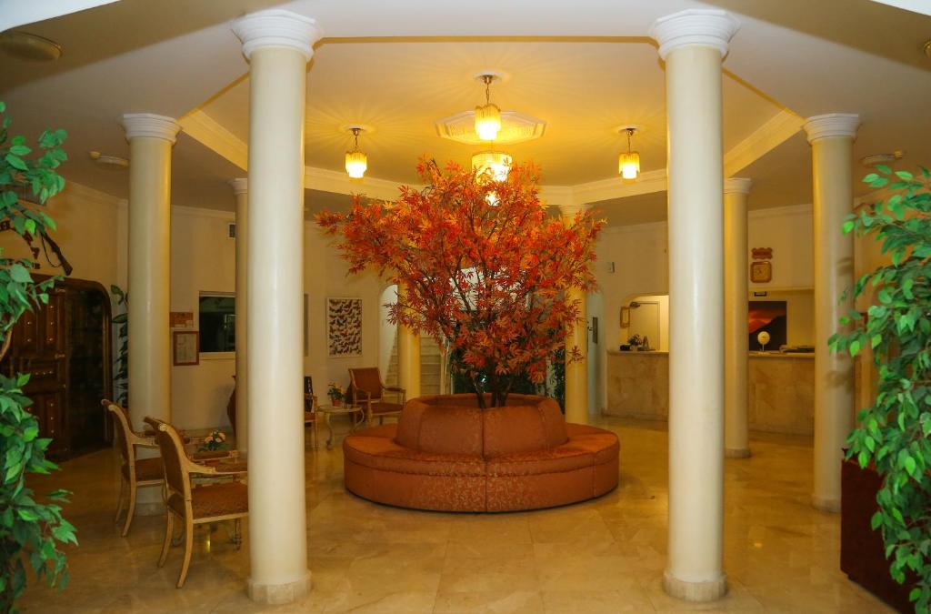 a lobby with a fountain with a tree in it at Fujairah Hotel & Resort in Fujairah