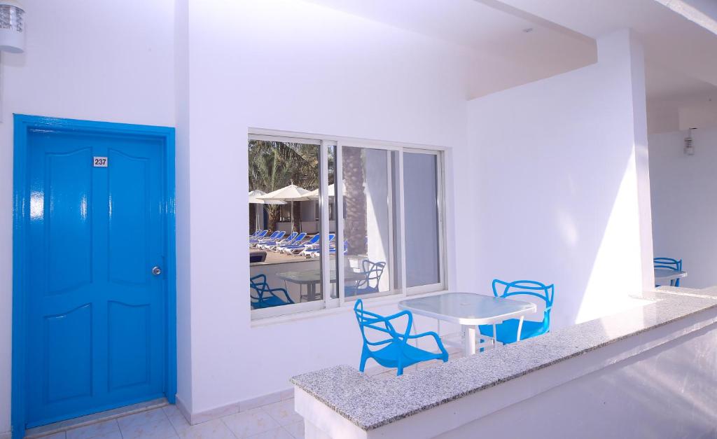 a room with a blue door and a table and chairs at Fujairah Hotel & Resort in Fujairah