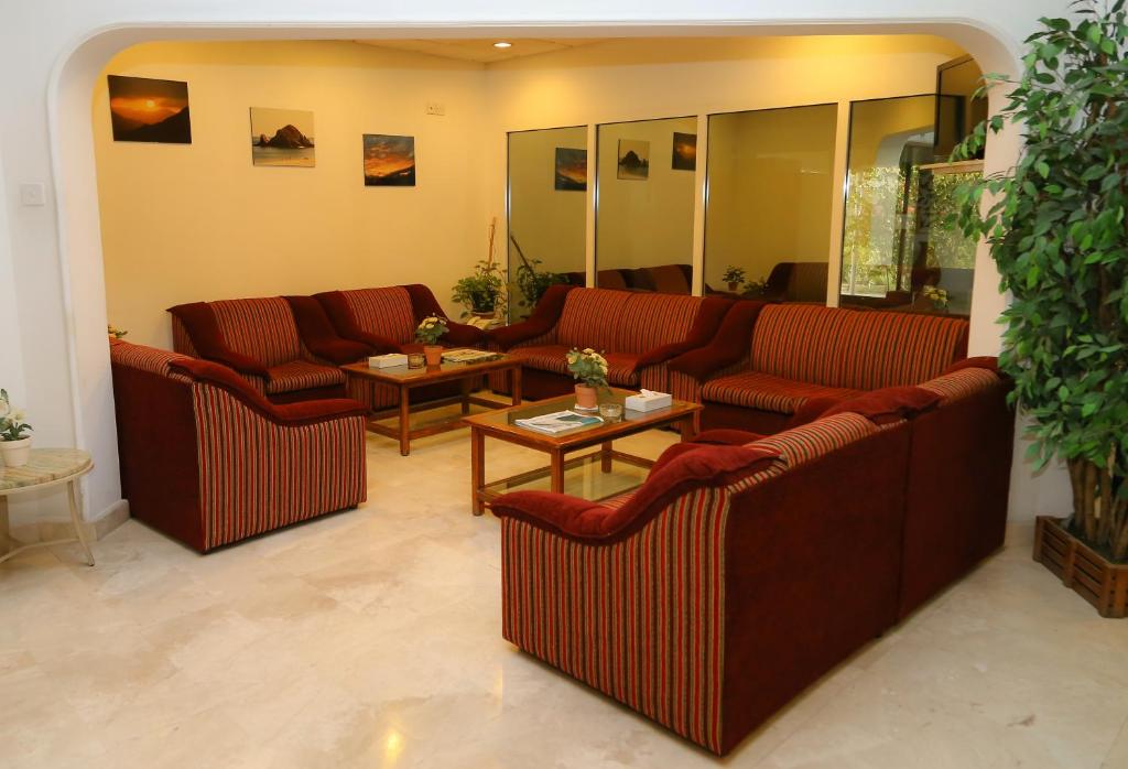 a living room with couches and tables in a room at Fujairah Hotel & Resort in Fujairah