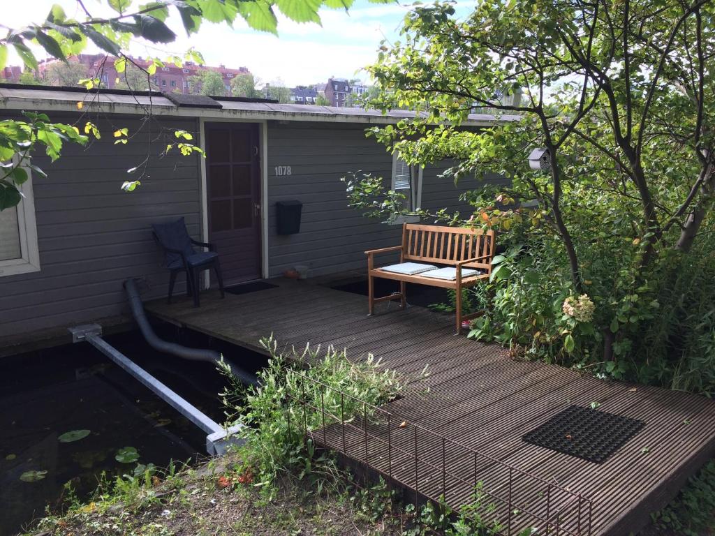 a wooden deck with a bench on a house at Tiny Houseboat B&B on the Amstel River in Amsterdam