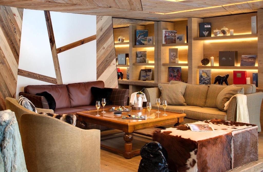 a living room with a couch and a table at Hôtel Les Barmes De l'Ours in Val-d'Isère