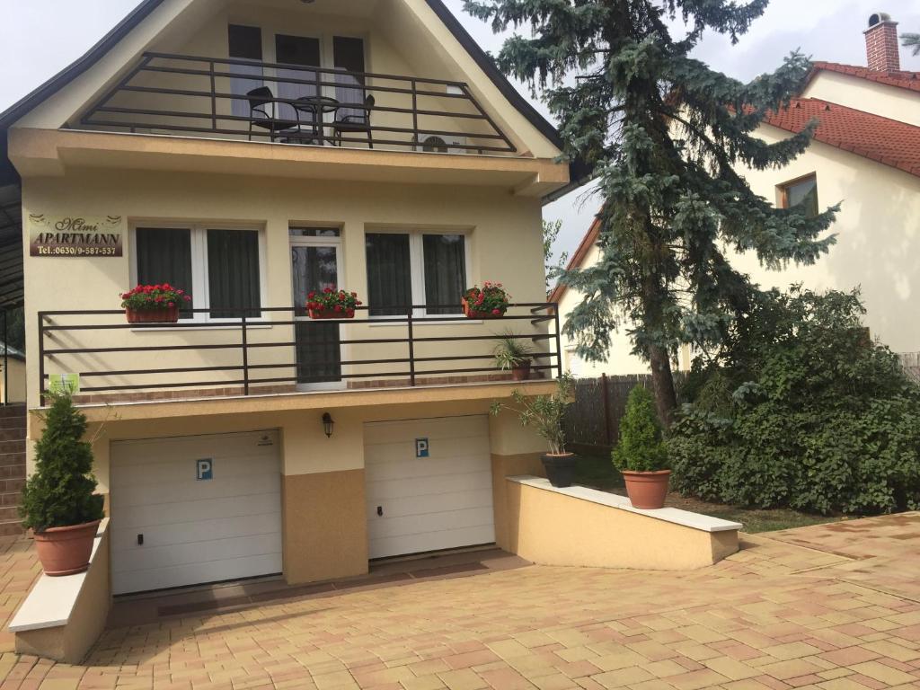 a house with two garage doors and a balcony at Mimi Apartment in Nyíregyháza