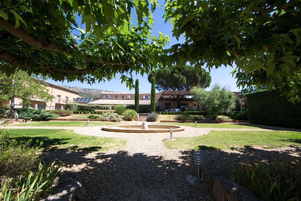 un jardin avec une fontaine au milieu d'un parc dans l'établissement Mercure Aix-En-Provence Sainte-Victoire, à Châteauneuf-le-Rouge