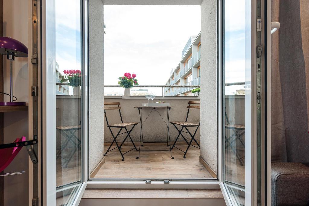 a room with a balcony with a view of a table at Emili Plater 12 P&O Apartments in Warsaw