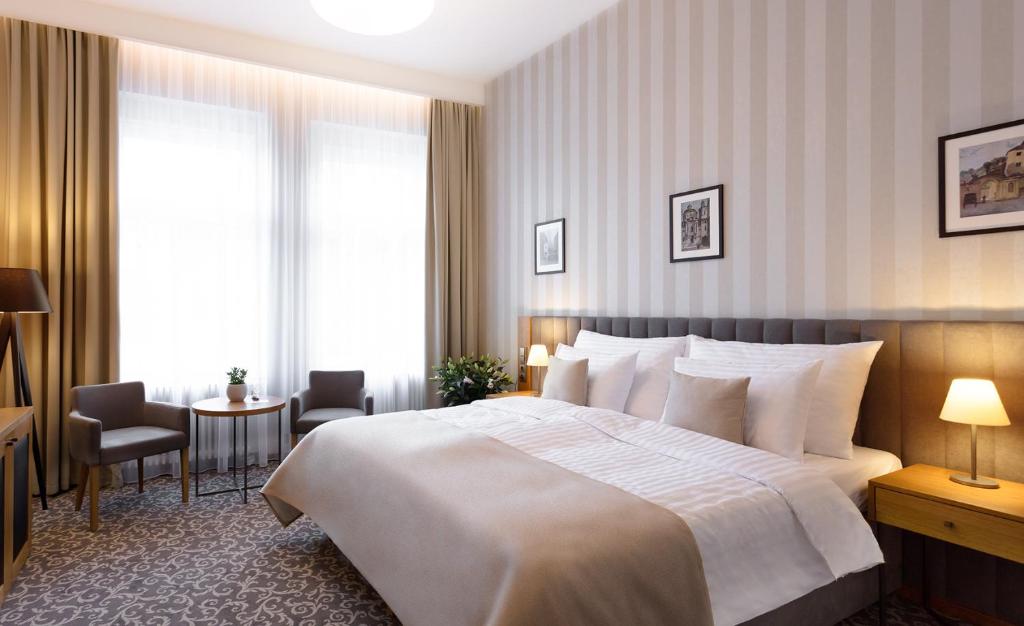 pokój hotelowy z dużym łóżkiem i stołem w obiekcie Hotel Schwaiger w Pradze