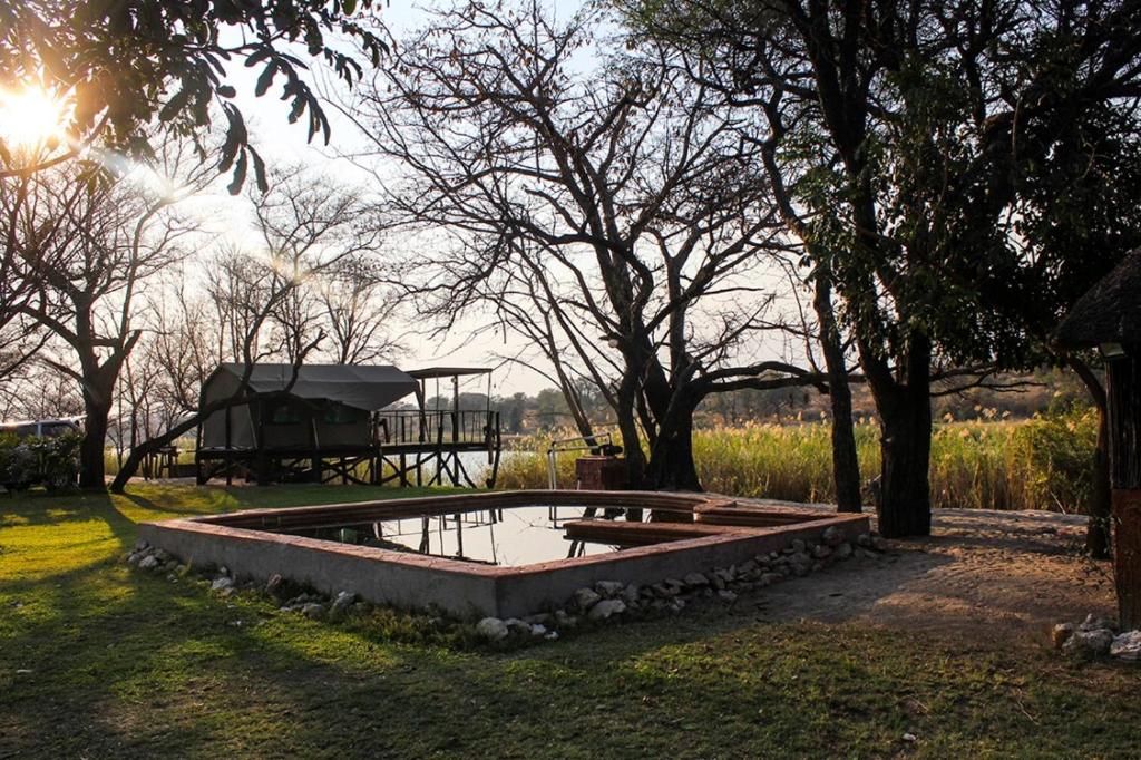 a small pond with a gazebo in a park at Camp Hogo Kavango in Rundu