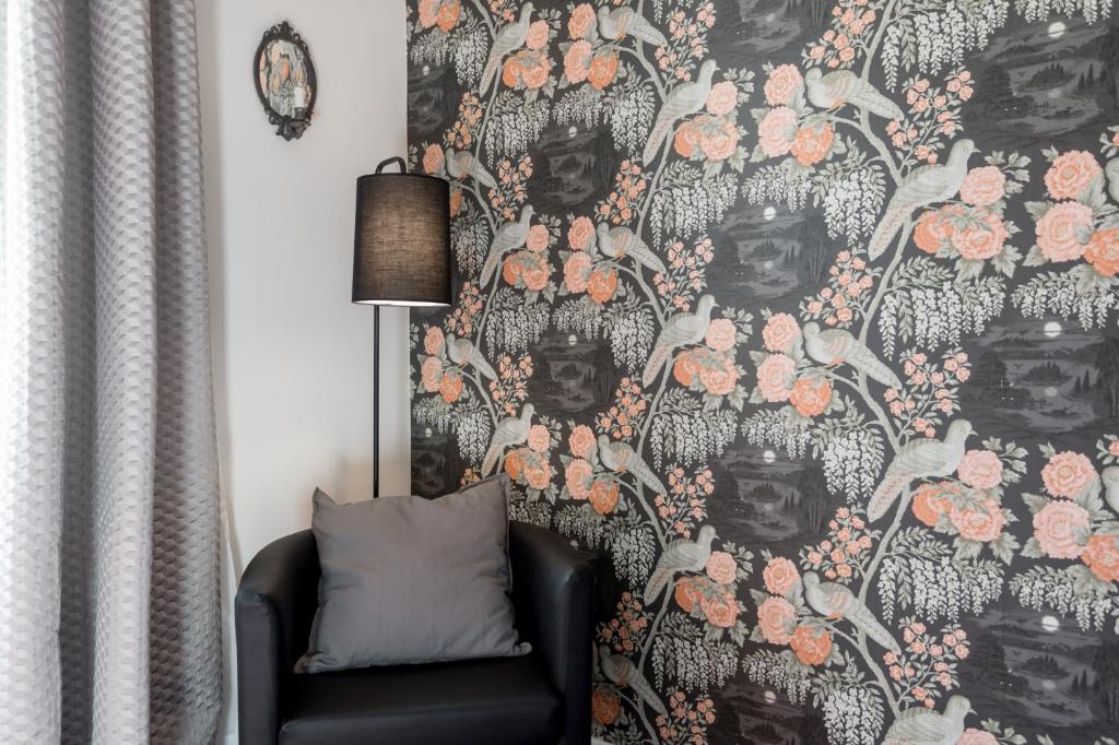 a living room with a wall with a floral wallpaper at L'8 Boutique Concept Apartments in Bologna