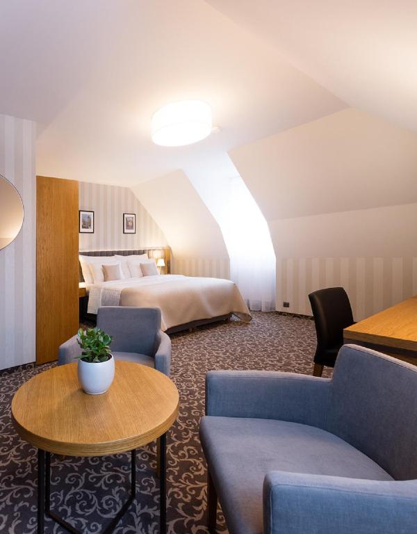pokój hotelowy z 2 łóżkami i stołem w obiekcie Hotel Schwaiger w Pradze