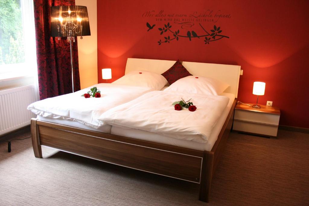 a bedroom with a bed with two flowers on it at Gästehaus Graul in Goslar