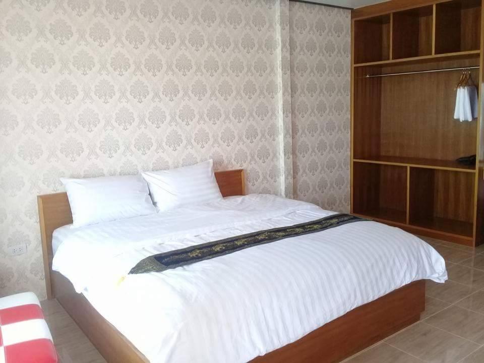 1 dormitorio con 1 cama grande con sábanas blancas en Mailuay Resort, en Buriram