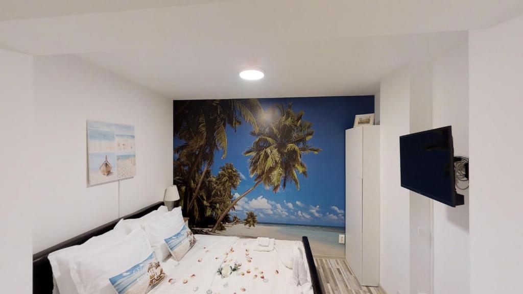 a bedroom with a bed and a mural of a palm tree at Sun Villa Residence in Bucharest