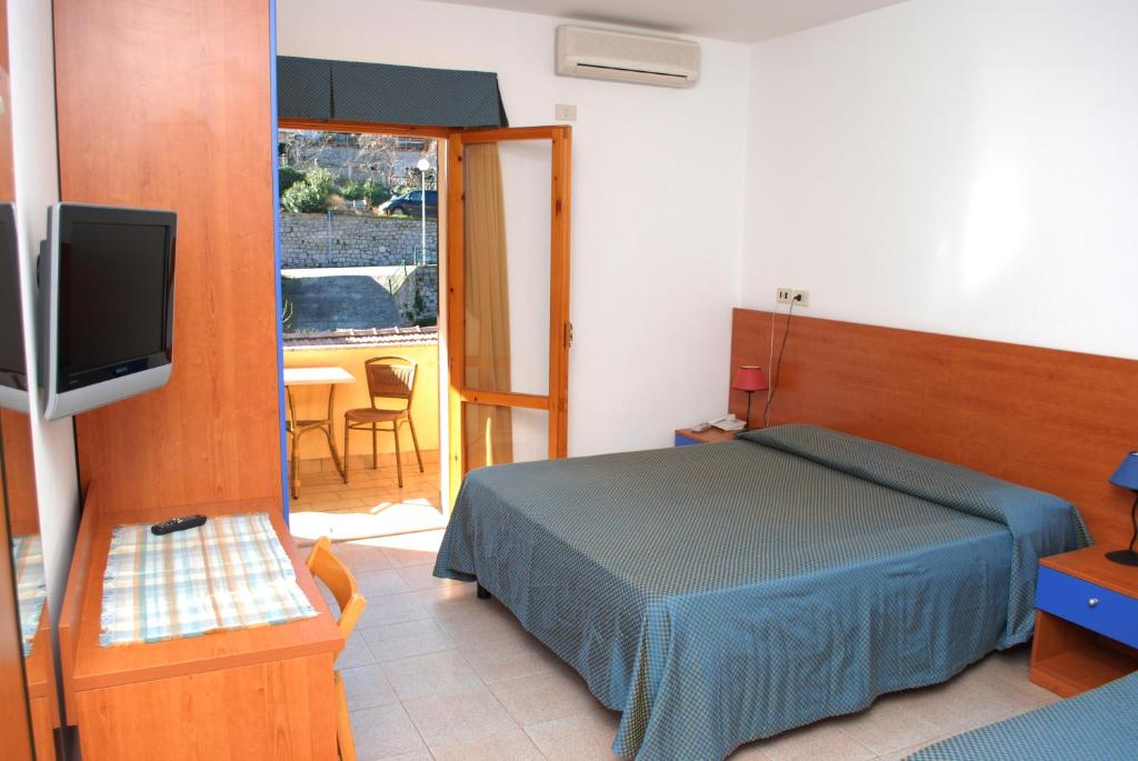a bedroom with a bed and a television and a table at Hotel Da Fine in Seccheto