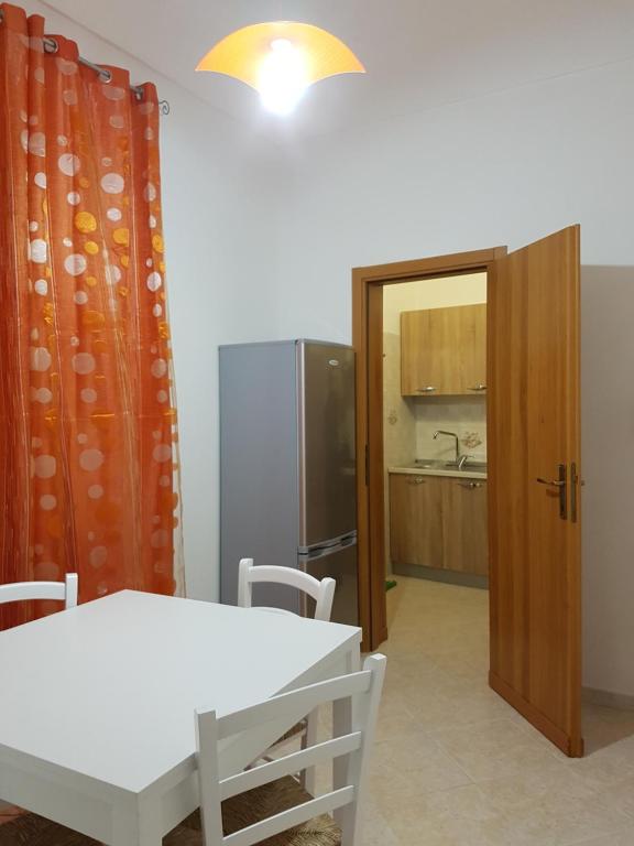 eine Küche mit einem weißen Tisch und einem Kühlschrank in der Unterkunft Alla casa di Anna in Trapani