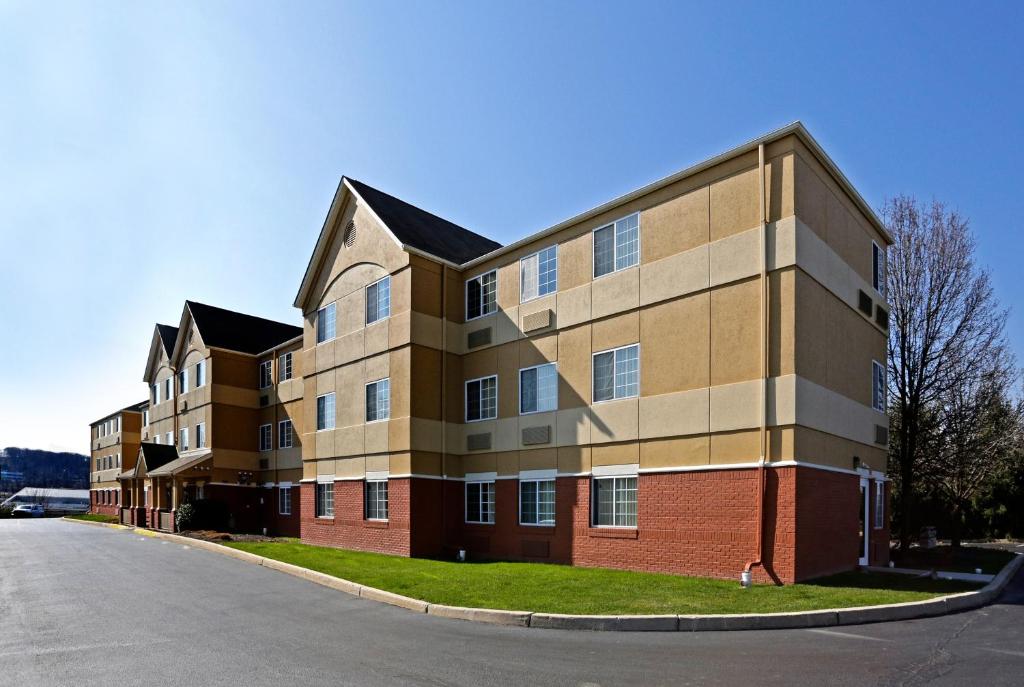 a large brick building with a clock on the side of the building at Extended Stay America Suites - Philadelphia - Malvern - Swedesford Rd in Malvern