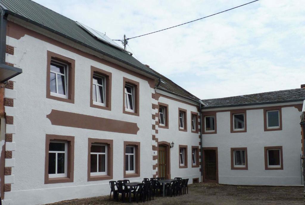 een groep gebouwen met tafels op de binnenplaats bij Eifel Ferienhaus Rodershausen in Rodershausen