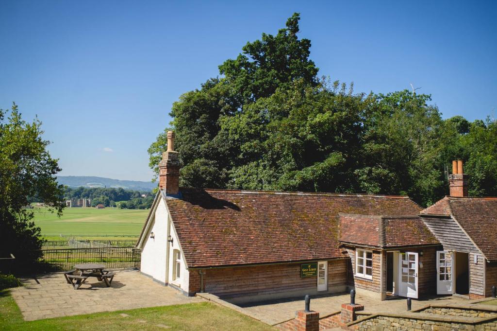 uma casa velha com uma mesa de piquenique em frente em Cowdray Lodge em Midhurst