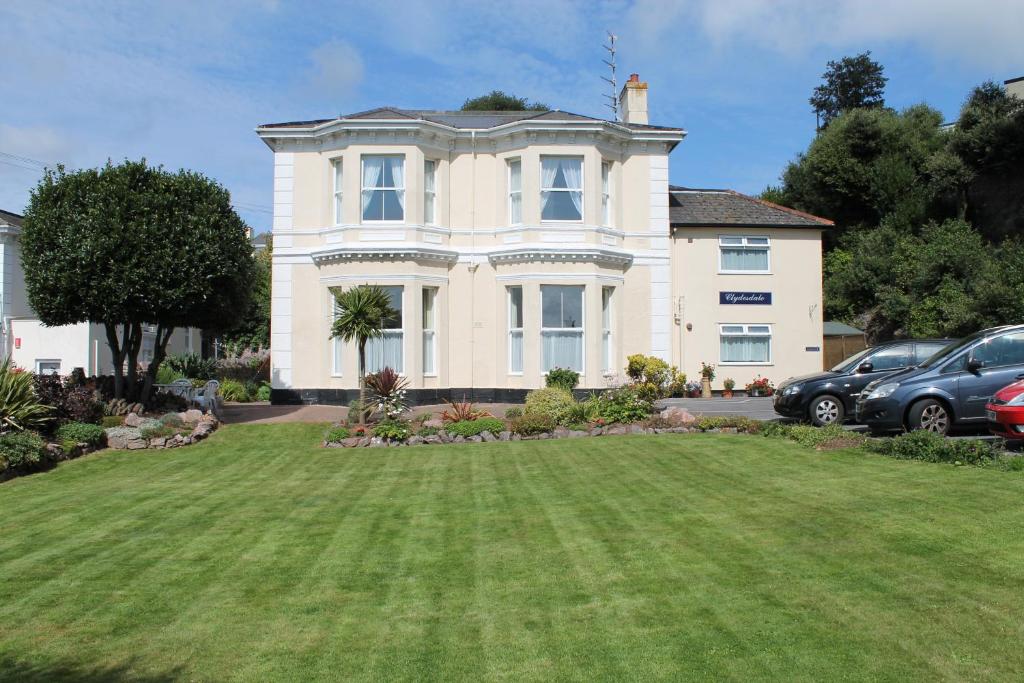 uma casa grande com um grande relvado em frente em Clydesdale Apartments em Torquay