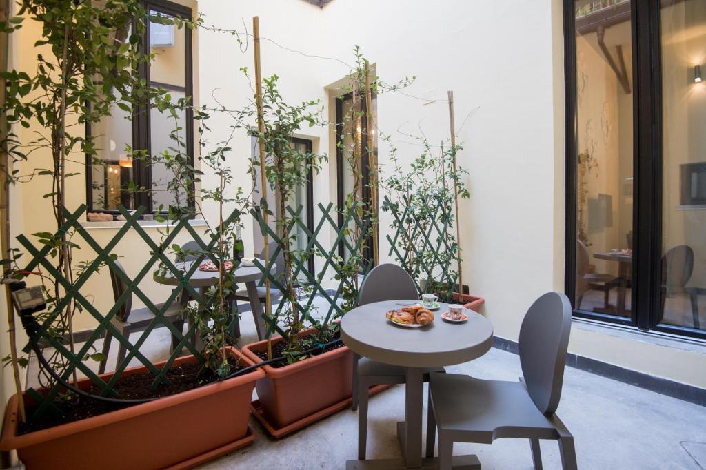 patio ze stołem, krzesłami i roślinami w obiekcie L'8 Boutique Design Apartments w Bolonii