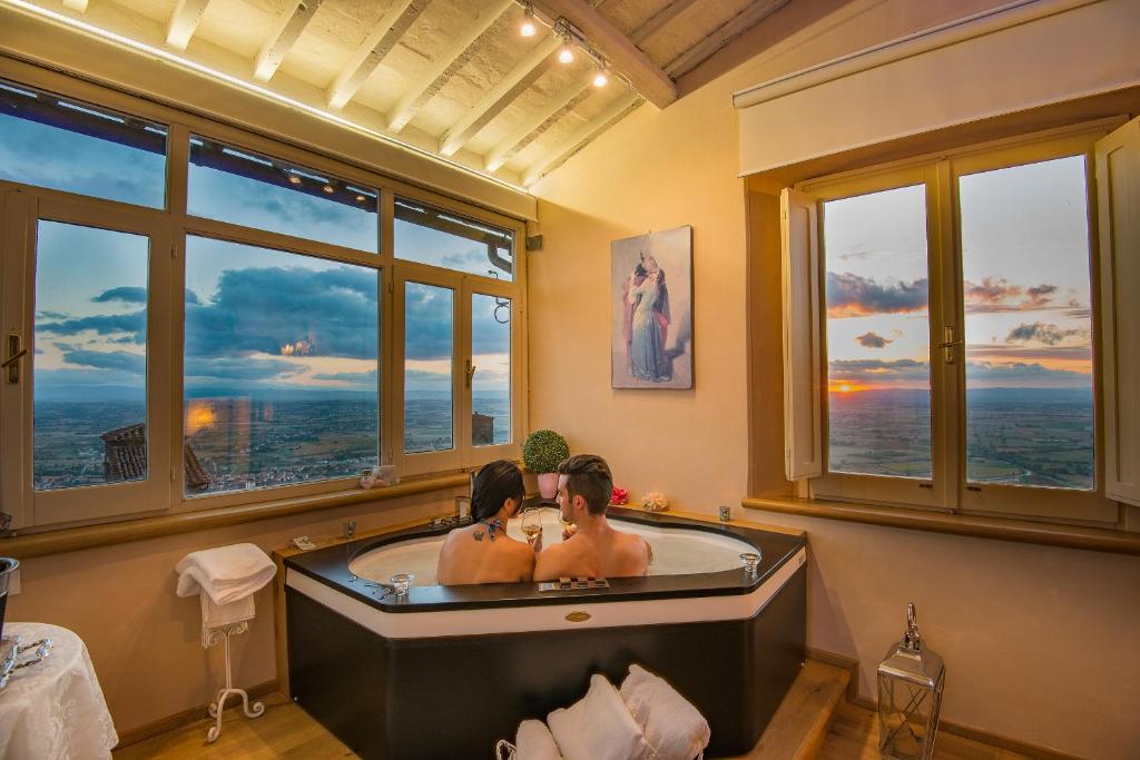 a bath room with a large tub and a large window at Hotel San Michele in Cortona