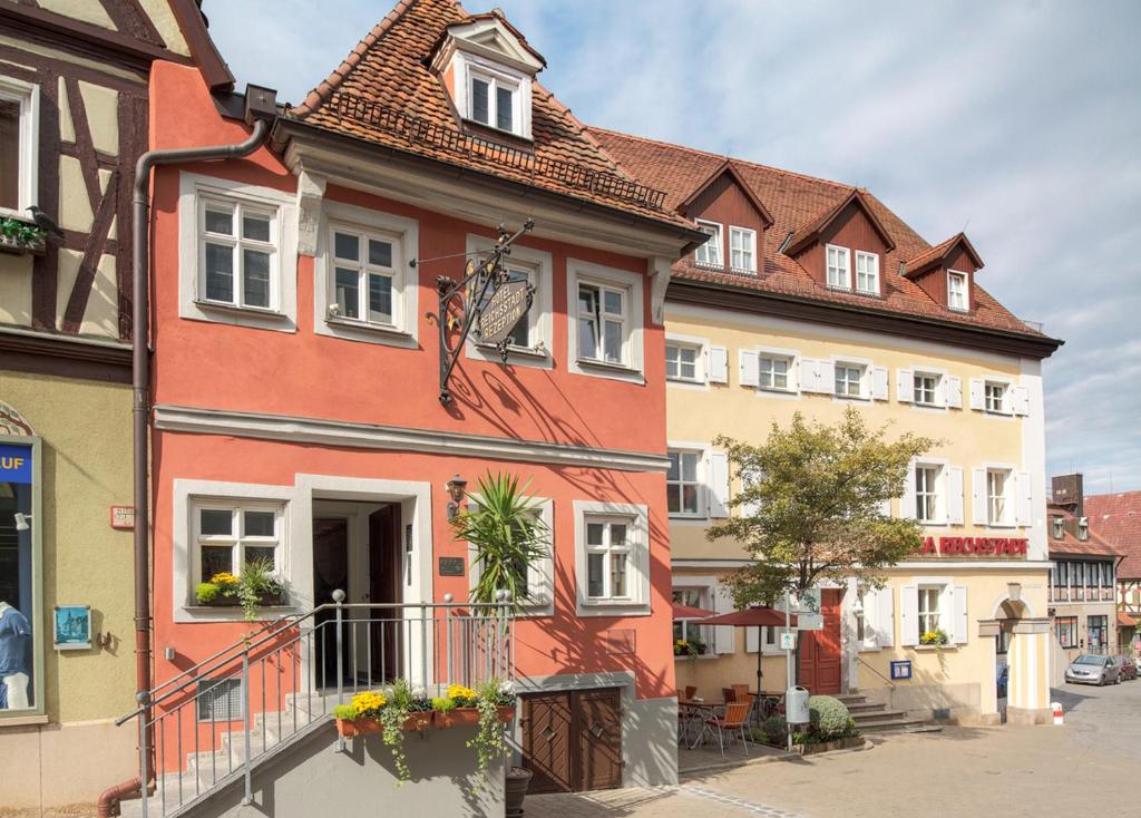 ein farbenfrohes Haus in einer Stadt mit Gebäuden in der Unterkunft Arvena Reichsstadt Hotel in Bad Windsheim