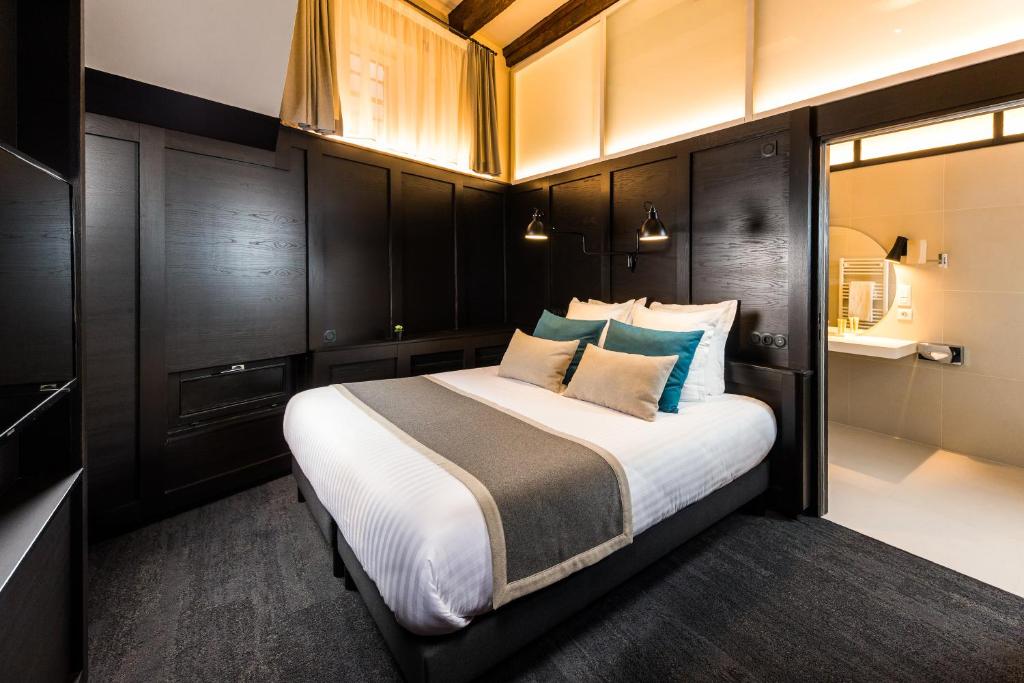 a bedroom with a large bed with black cabinets at Hôtel Du Dragon in Strasbourg