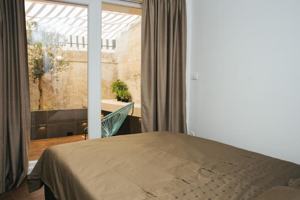 a bedroom with a bed and a large window at Marinac City Center Apartments & Rooms in Split