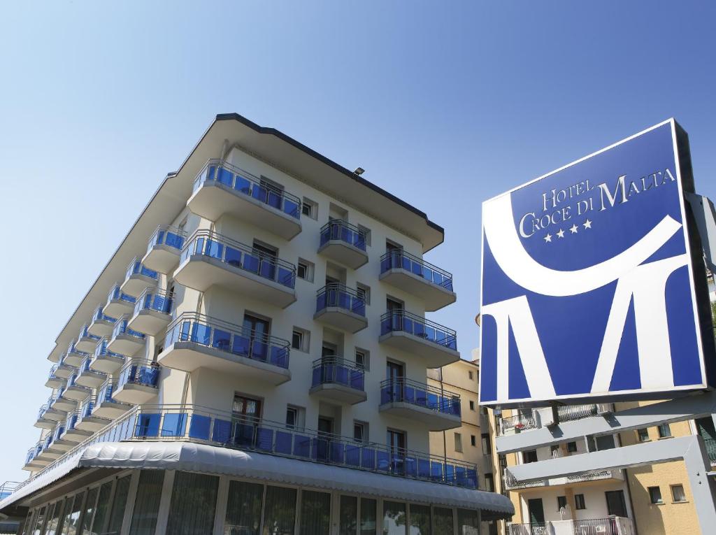 un bâtiment avec un panneau devant lui dans l'établissement Hotel Croce Di Malta, à Lido di Jesolo