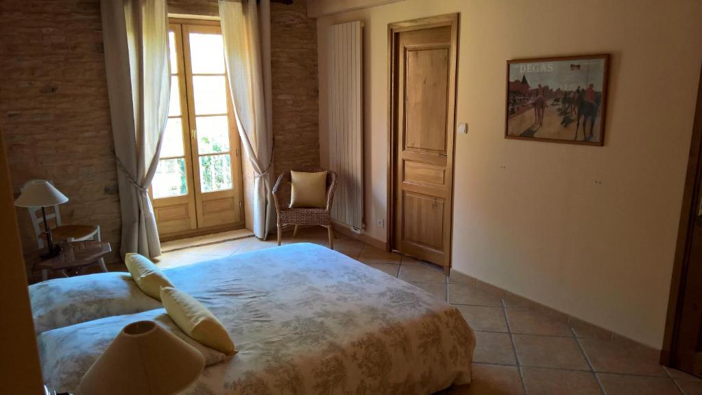 a bedroom with a large bed and a window at Le Clos des Pierres Dorées in Theizé