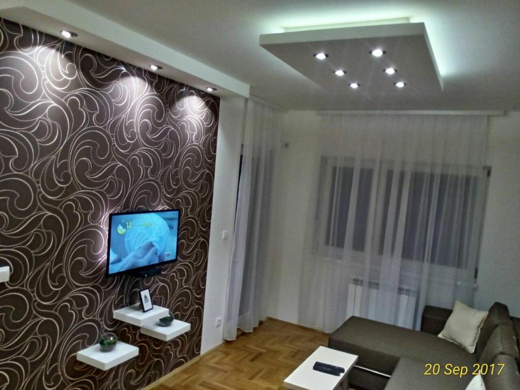 salon z telewizorem na ścianie w obiekcie Apartment Frida w Belgradzie