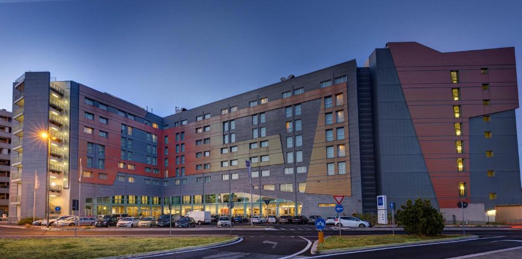 a large building with cars parked in front of it at iH Hotels Roma Z3 in Rome