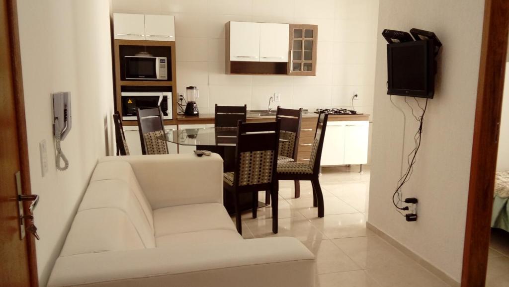 sala de estar con sofá, mesa y sillas en Apartamento novo 450 mt da praia Ingleses, en Florianópolis