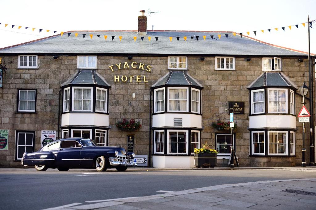 um carro velho estacionado em frente a um hotel em Tyacks Hotel em Camborne