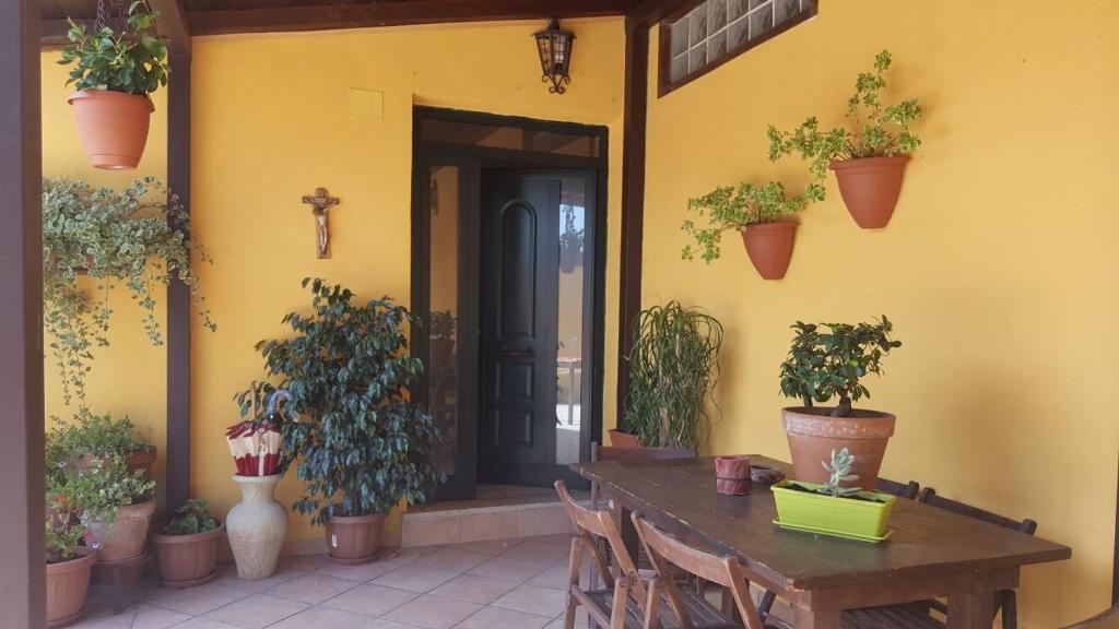 a porch with a wooden table with chairs and potted plants at Beb Da Tina in Roccasecca