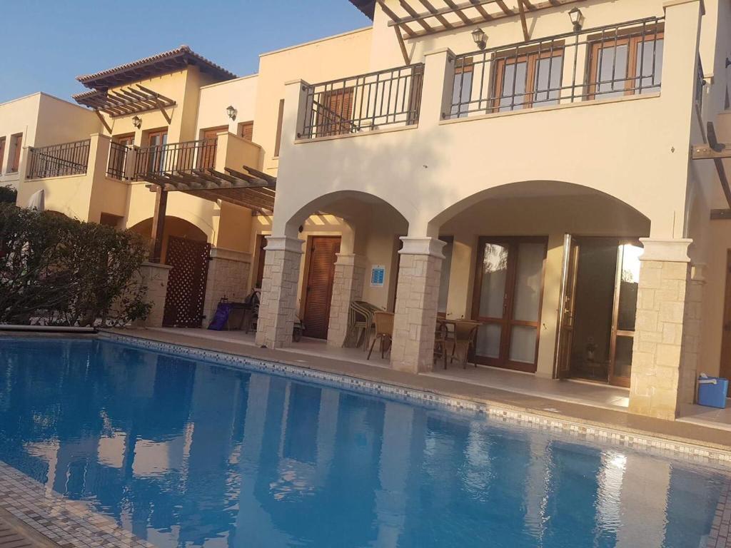 a large swimming pool in front of a house at Aphrodite Hills in Kouklia