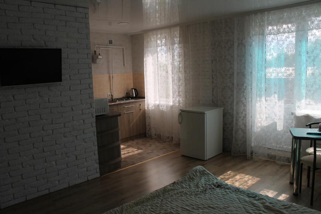 een woonkamer met een televisie en een keuken met een tafel bij Studio on main street in Bălţi