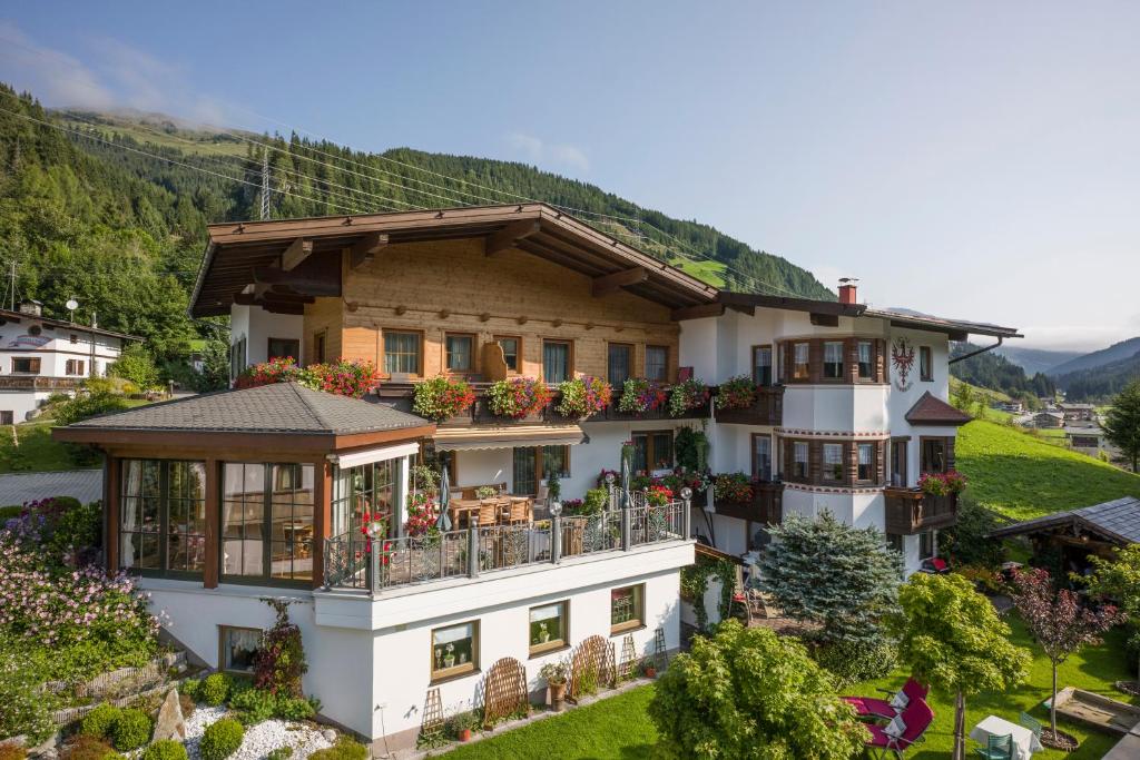 a large white house with flowers on the balcony at Landhaus Dengg in Gerlos