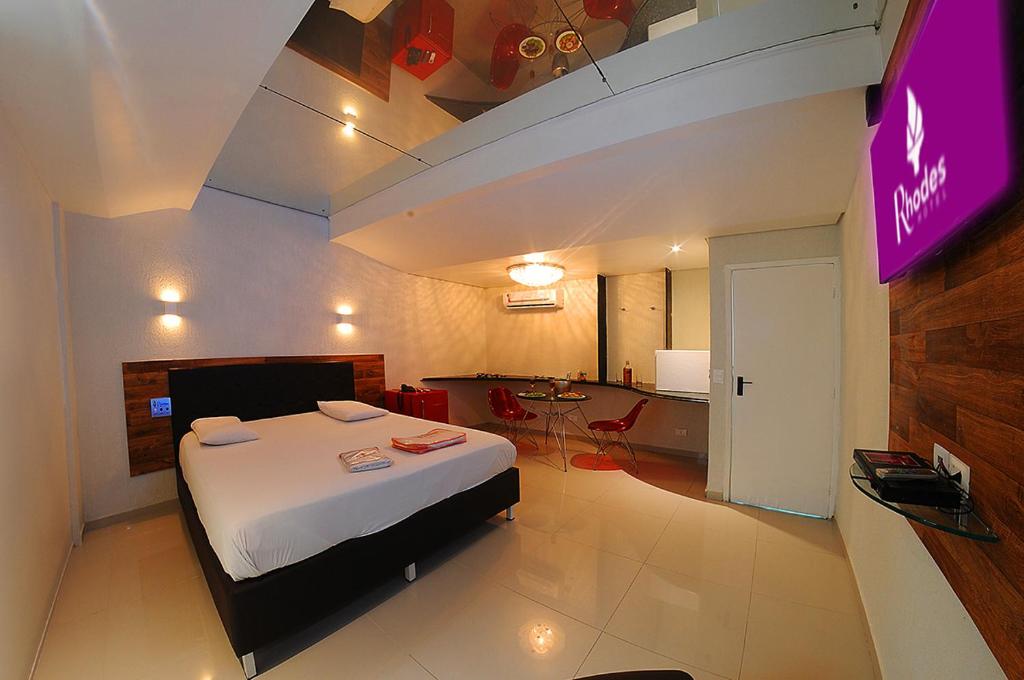 レシフェにあるRhodes Hotel Recifeのベッドとテレビ付きのホテルルーム