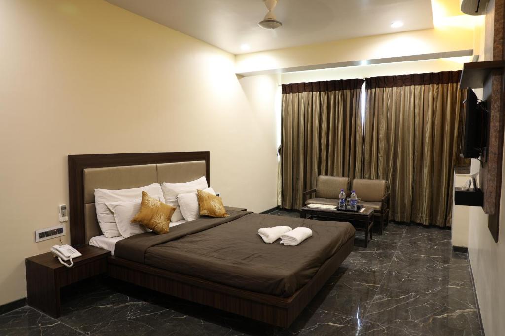 1 dormitorio con 1 cama con 2 toallas en Hotel Jawahar en Ulhāsnagar