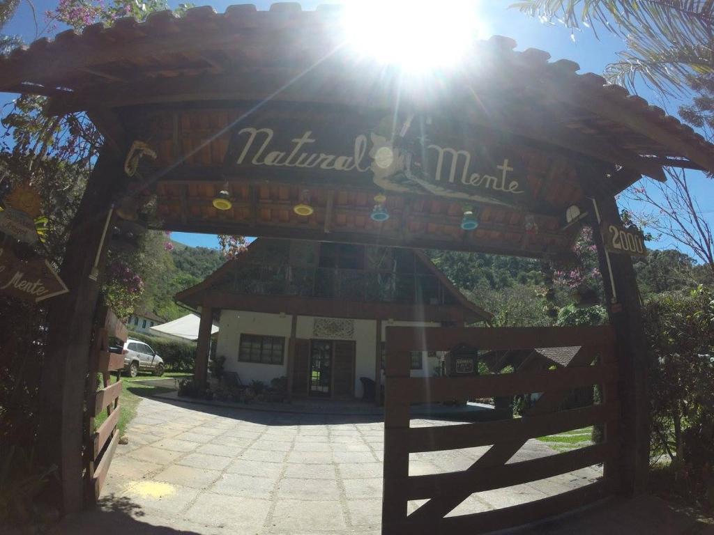 una entrada a un mercado natural con el sol brillando en Pousada Naturalmente en Visconde De Maua