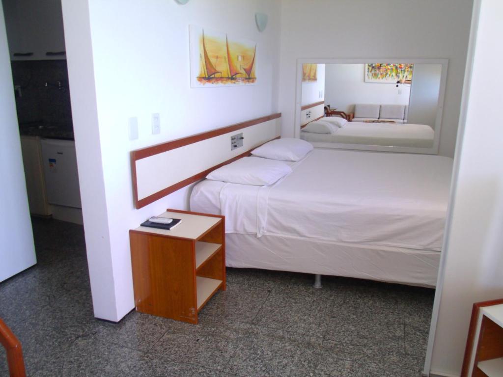 a small bedroom with two beds and a table at Iracema Residence Hotel Flat in Fortaleza